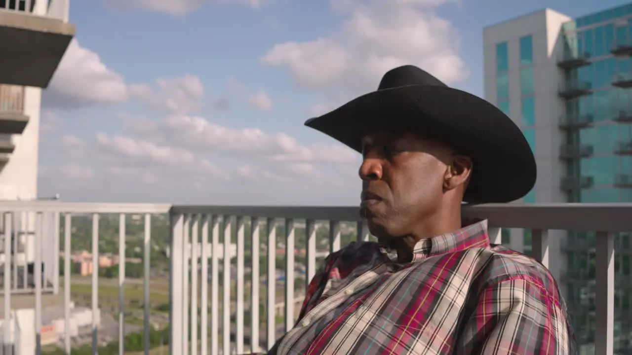 Black male with cowboy hat sleep on Balcony