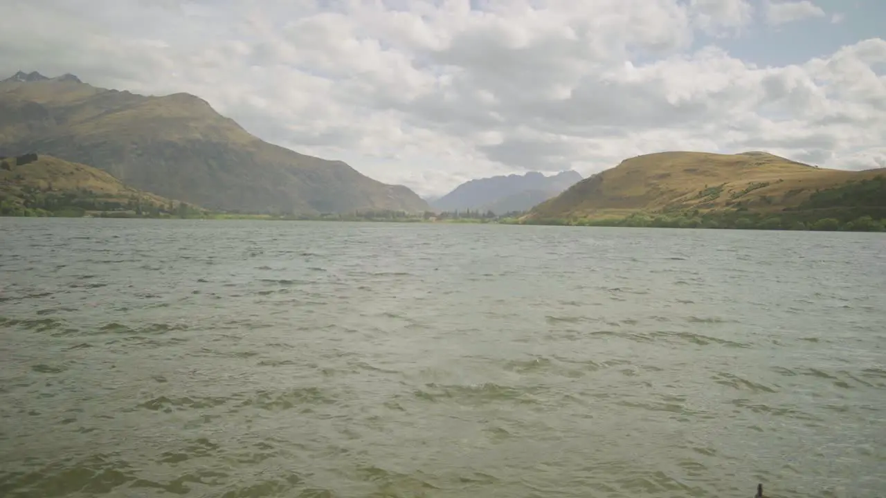 steady shot of the surface of lake hayes revealing the hills