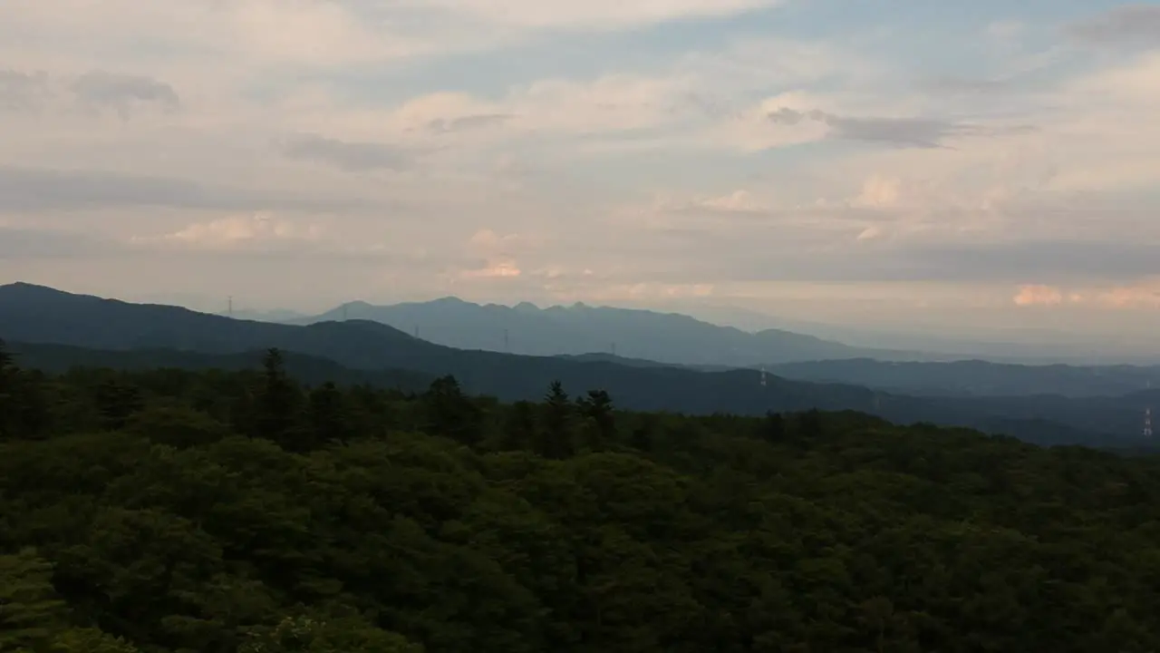 Drone shot of the forest-covered mountains outside Karuizawa Japan as the sun is setting