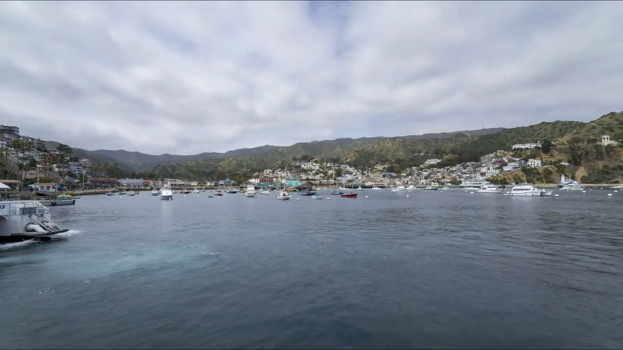 Timelapse of the Ferry arriving and boats bobbing in the harbor with clouds passing overhead on Catalina Island in Southern Californian Pacific Ocean