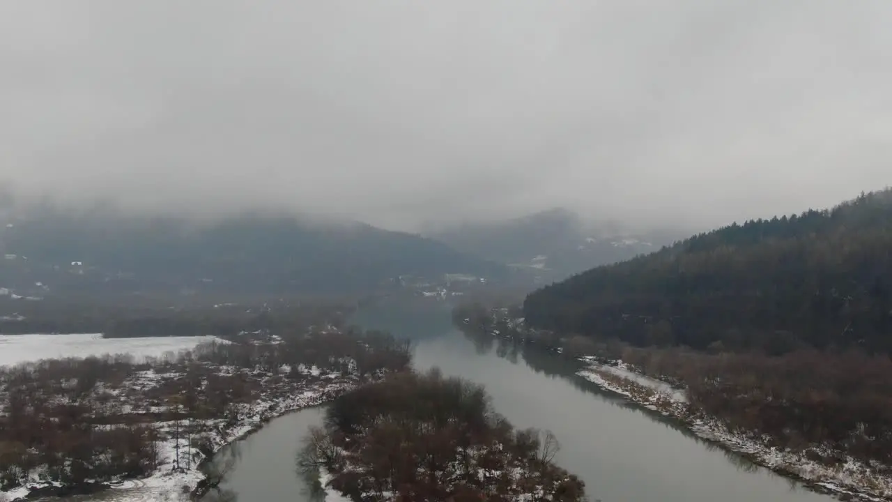 Serene mountain river valley aerial panorama on cold winter stormy day