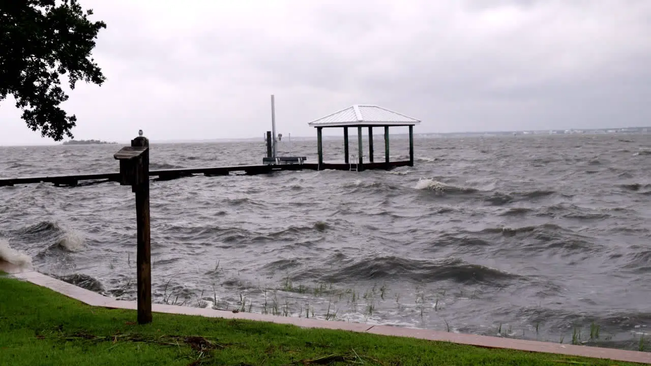 Wide shot of waves splashing over a dock from a hurricane storm surge