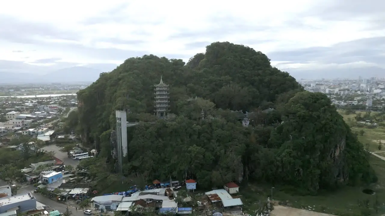 Beautiful aerial shot of the green and lush Marble Mountain in the city Da Nang Vietnam on a cloudy day