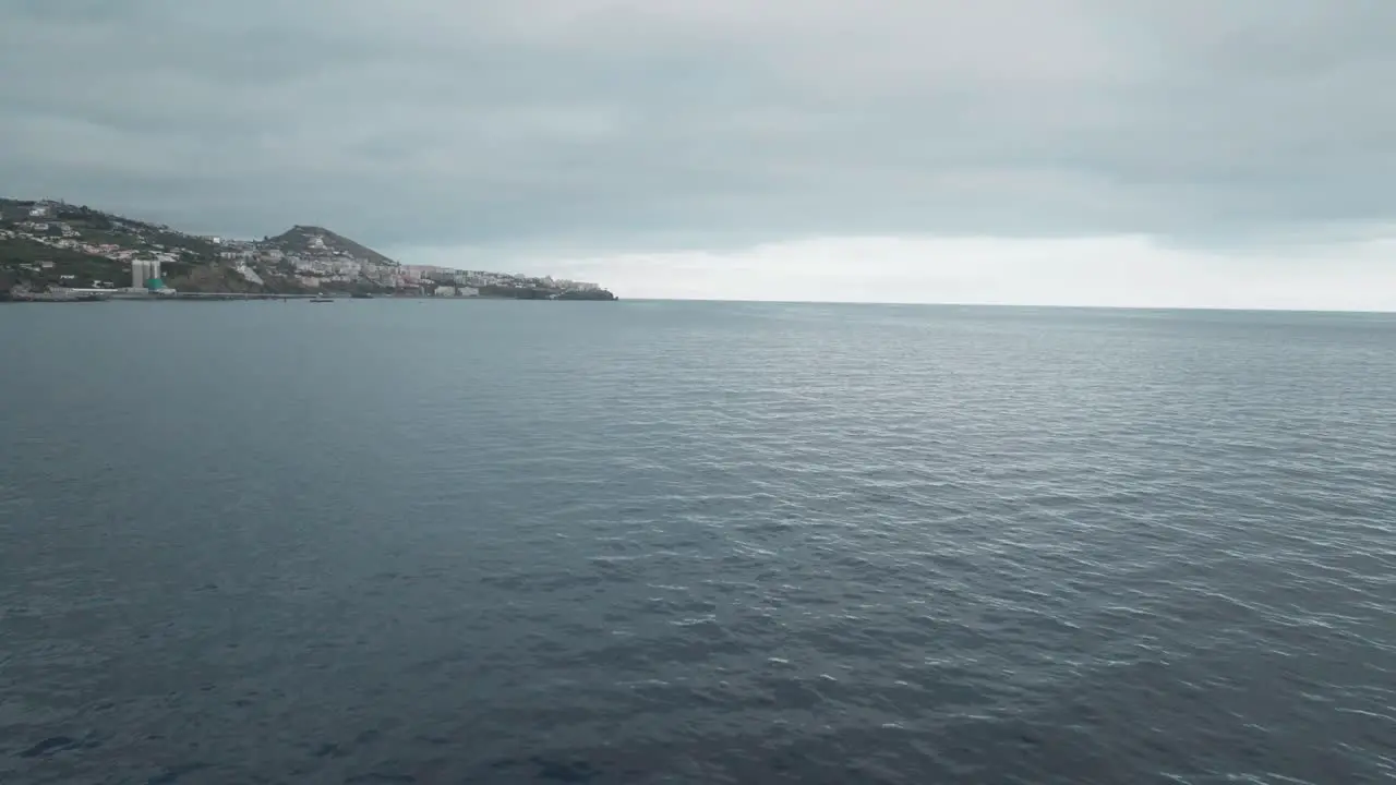 Catamaran Boat Sailing On The Atlantic Ocean Towards City Of Funchal In Madeira Portugal On A Cloudy Day