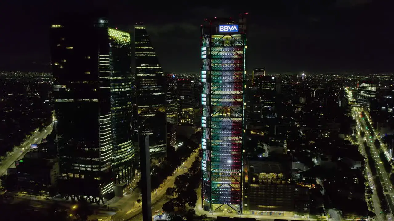 Aerial view around the BBVA tower illuminated in the colors of the Mexican flag Independence day in Mexico city circling drone shot