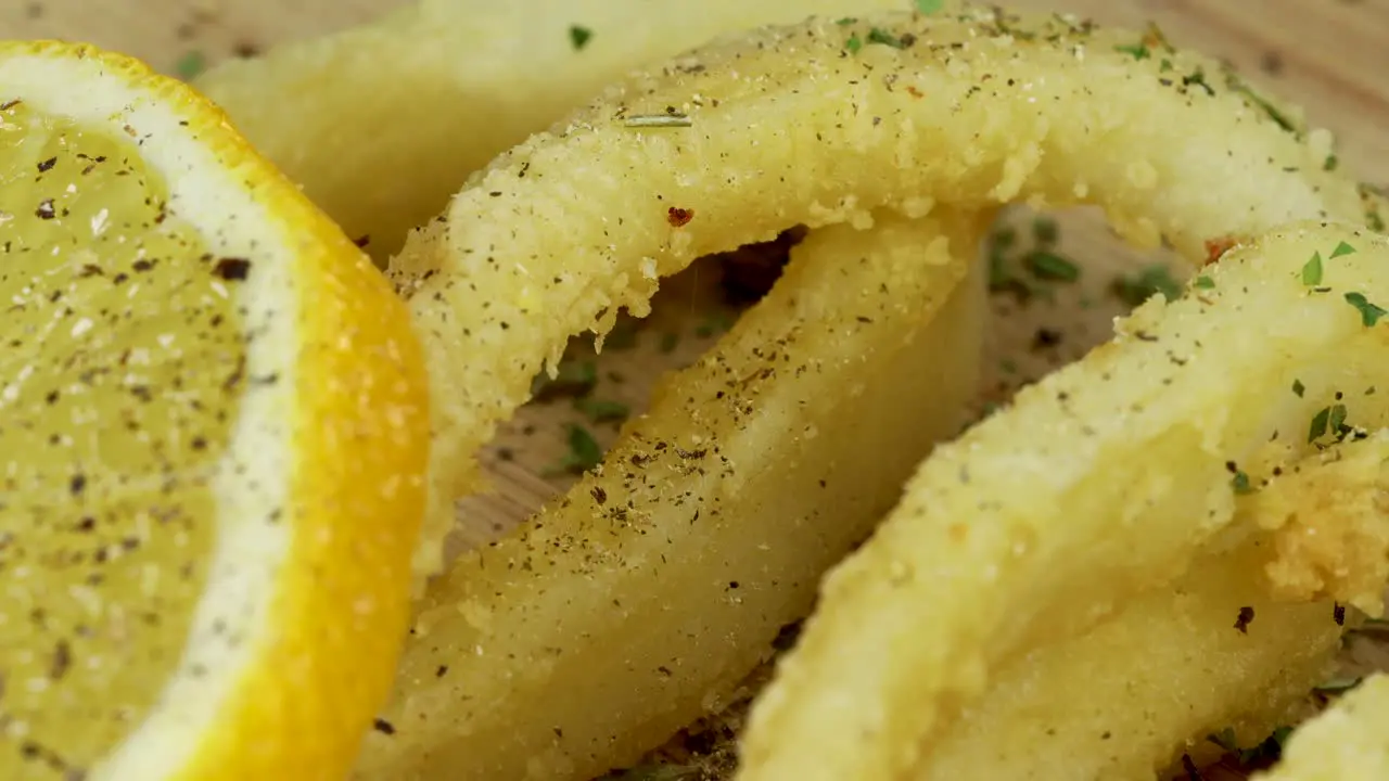 Macro shot of adding pepper to fried squid rings