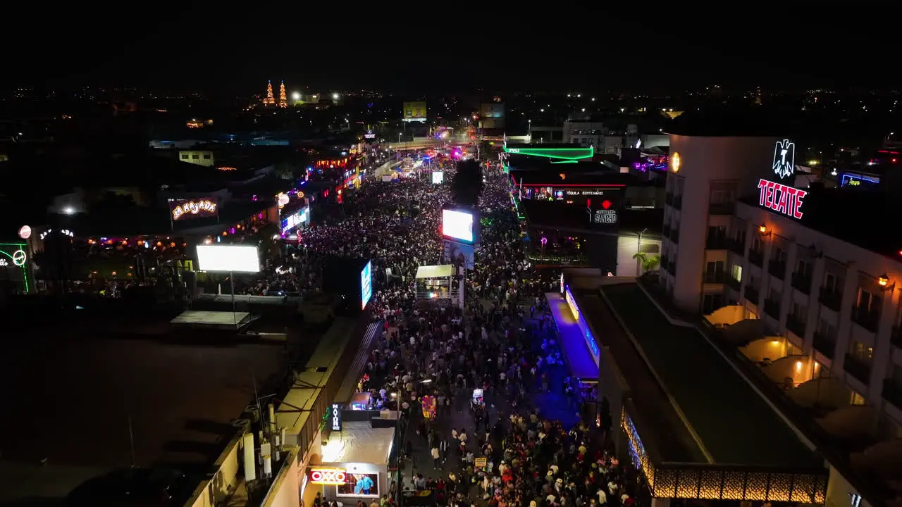 Flying over night lit streets of Aguascalientes during the San Marcos fair Aerial view