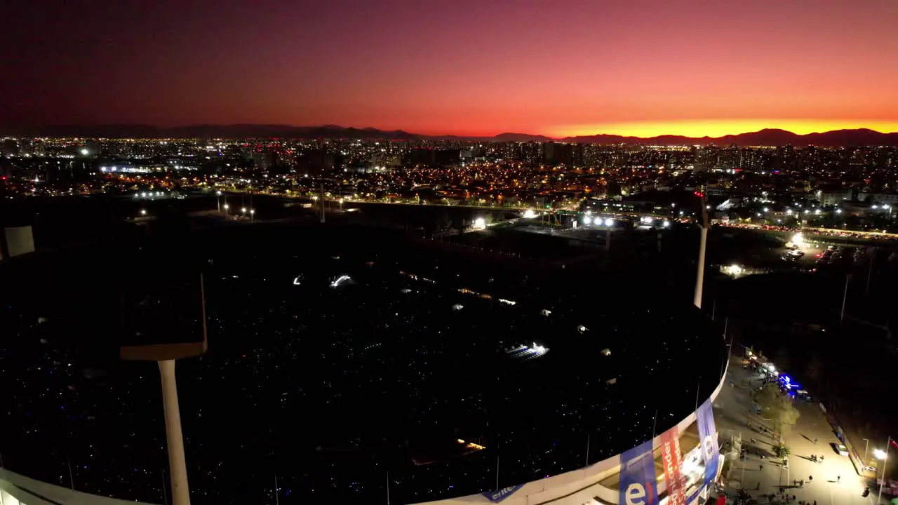 Incredible orange sunset over the night skyline of Santiago Chile revealing the national stadium