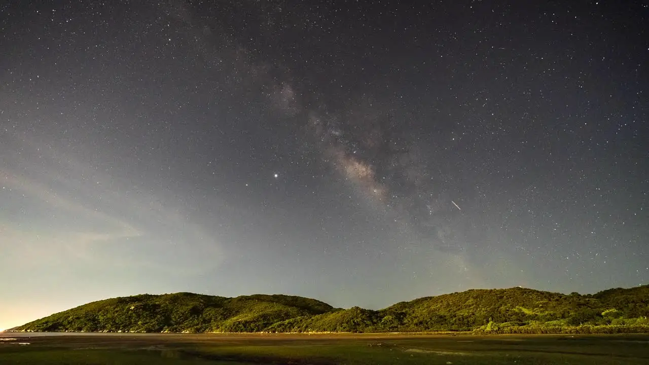 Magical milky way shooting stars airplane lights timelapse night sky over Lantau island coastal Hong Kong