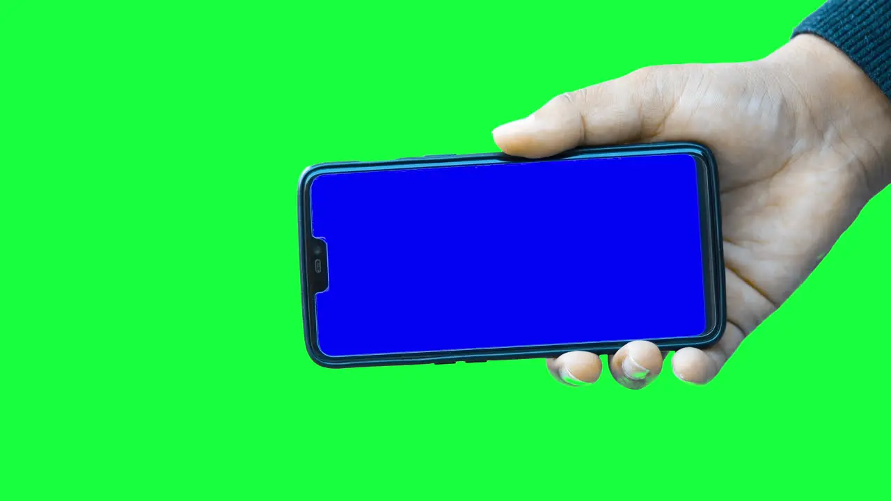 Hand of a man holds a modern smartphone mockup against the green screen chroma key