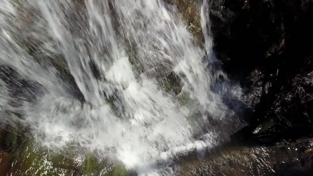 Aerial approach to the crest of a mountain waterfall near Blowing Rock North Carolina