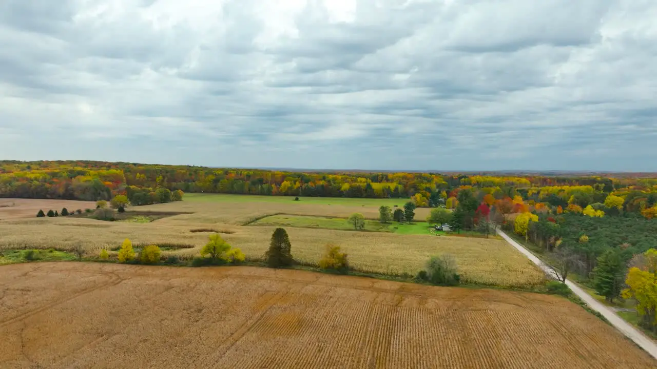 Pan from large turbine to fall colors on nearby trees