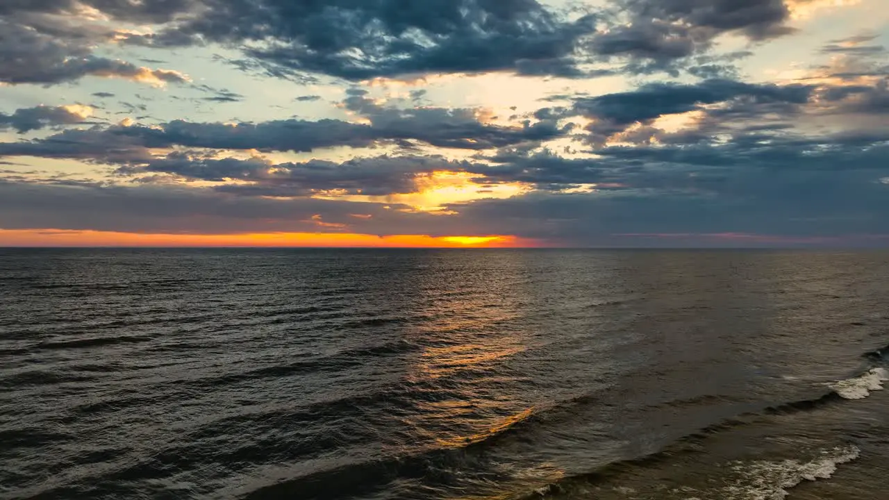 Dolly motion over lush sunset and rough water