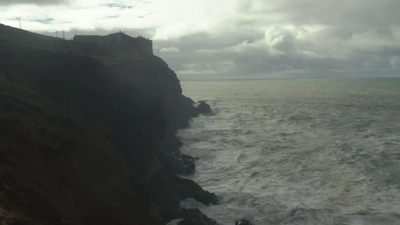 Stormy ocean or sea and rock cliffs in Nazare Portugal bad cloudy weather stable view