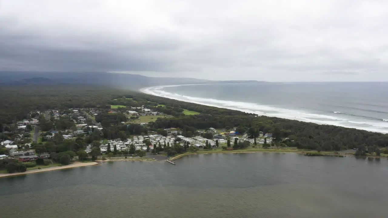 Aerial drone shot over Shoalhaven heads on a stormy day with the coastline stretching out to the horizon in south coast NSW Australia