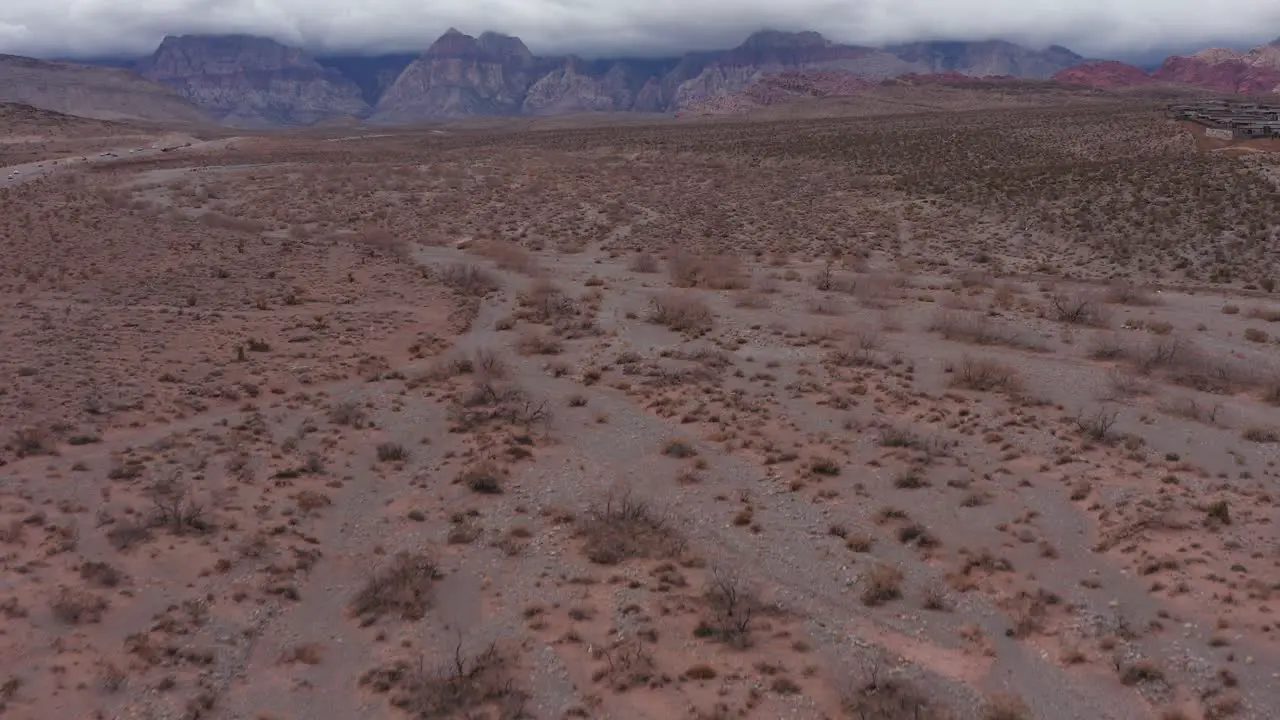 Low aerial shot tilting up to reveal Red Rock Canyon blanketed by thick clouds in Las Vegas Nevada