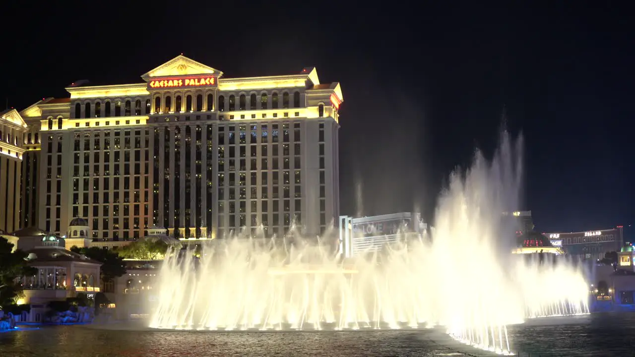 Bellagio fountain at night in front of Caesars Palace