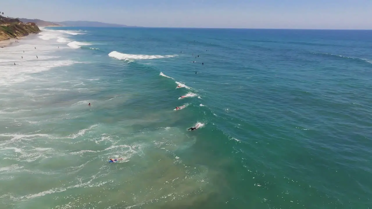 Surfers Riding Waves In Del Mar Beach In San Diego California aerial drone shot