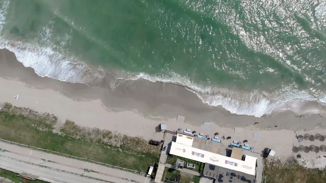 Top Down View Of Waves Splashing On Sandy Shore In Vama Veche Romania drone shot