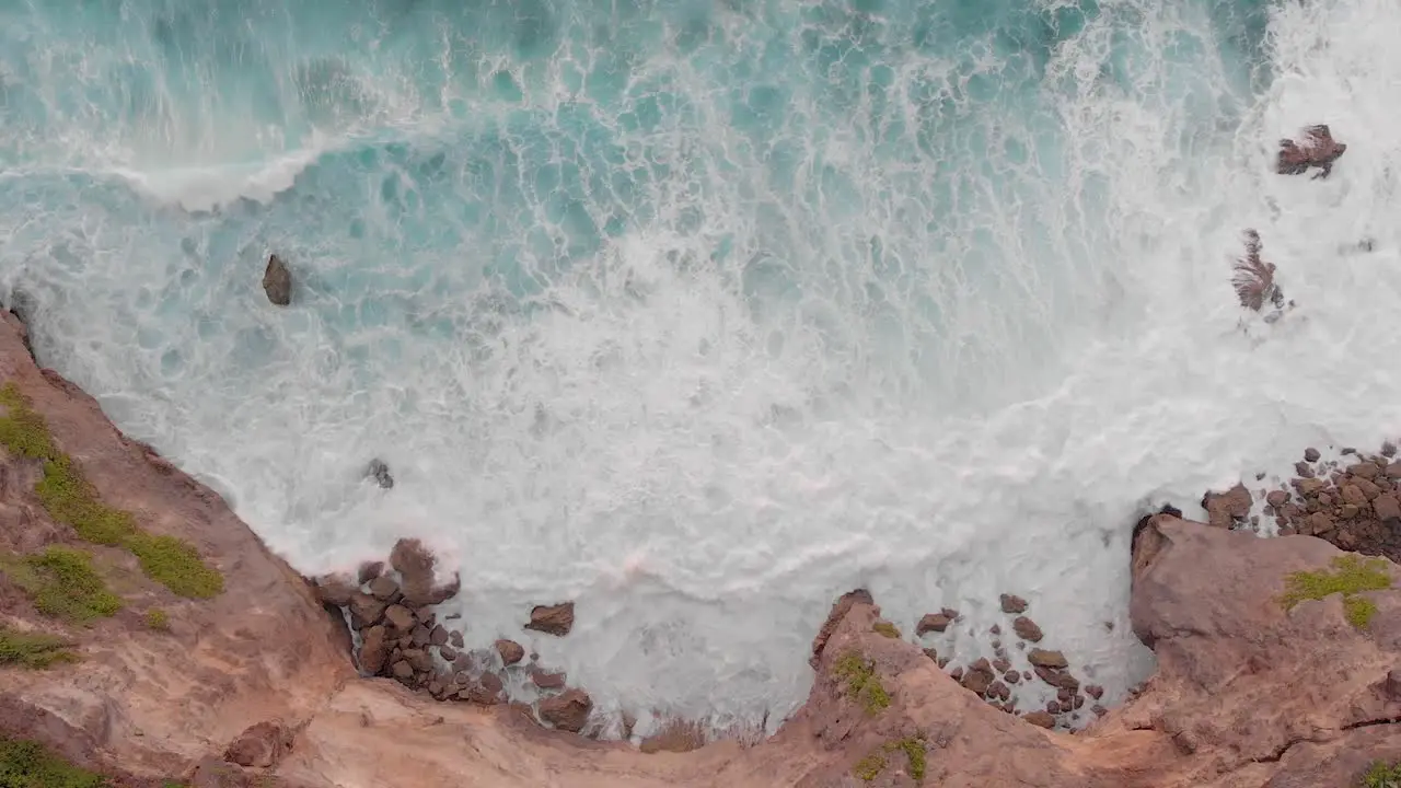 Cinematic smooth aerial drone shot of large waves crashing into huge cliff edge in uuwatu Bali during golden hour on summer sunset-4