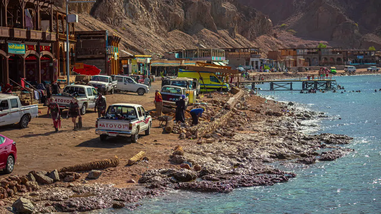 Shot of tourist vehicles along the shore with waves crashing in timelapse in Xlendi Beach in Malta