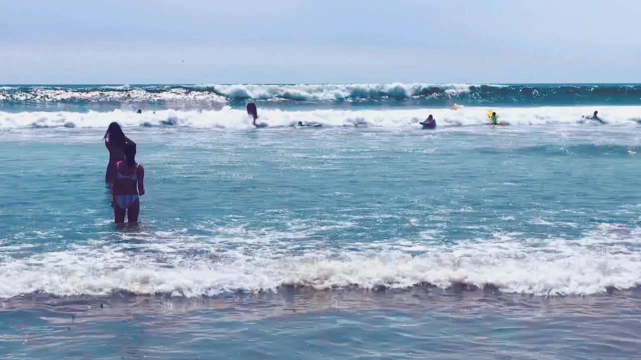 People enjoying themselves in the water with large waves at Pacific Beach in San Diego California