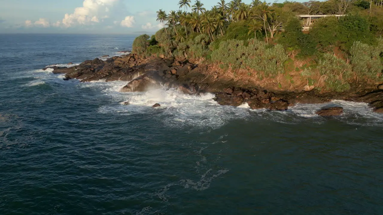 60 FPS Establishing Aerial Drone Shot towards Waves Crashing Against Rocks in Tropical Sri Lankan Coastline