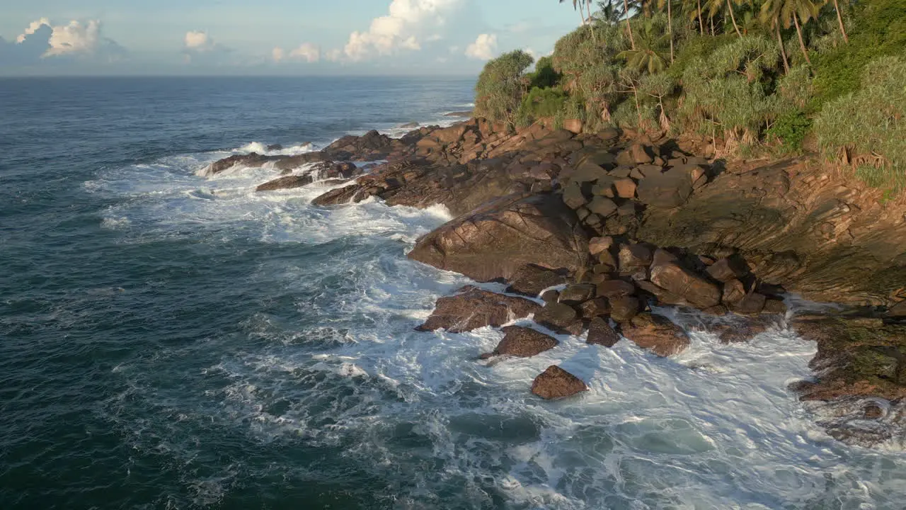 Aerial Drone Shot Rotating Around Rocky Shoreline in Tropical Sri Lanka with Waves Crashing 60 FPS