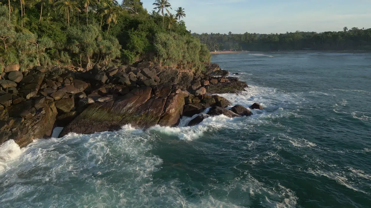 Low Aerial Drone Shot of Waves Crashing into Rocky Tropical Coastline in South Sri Lanka