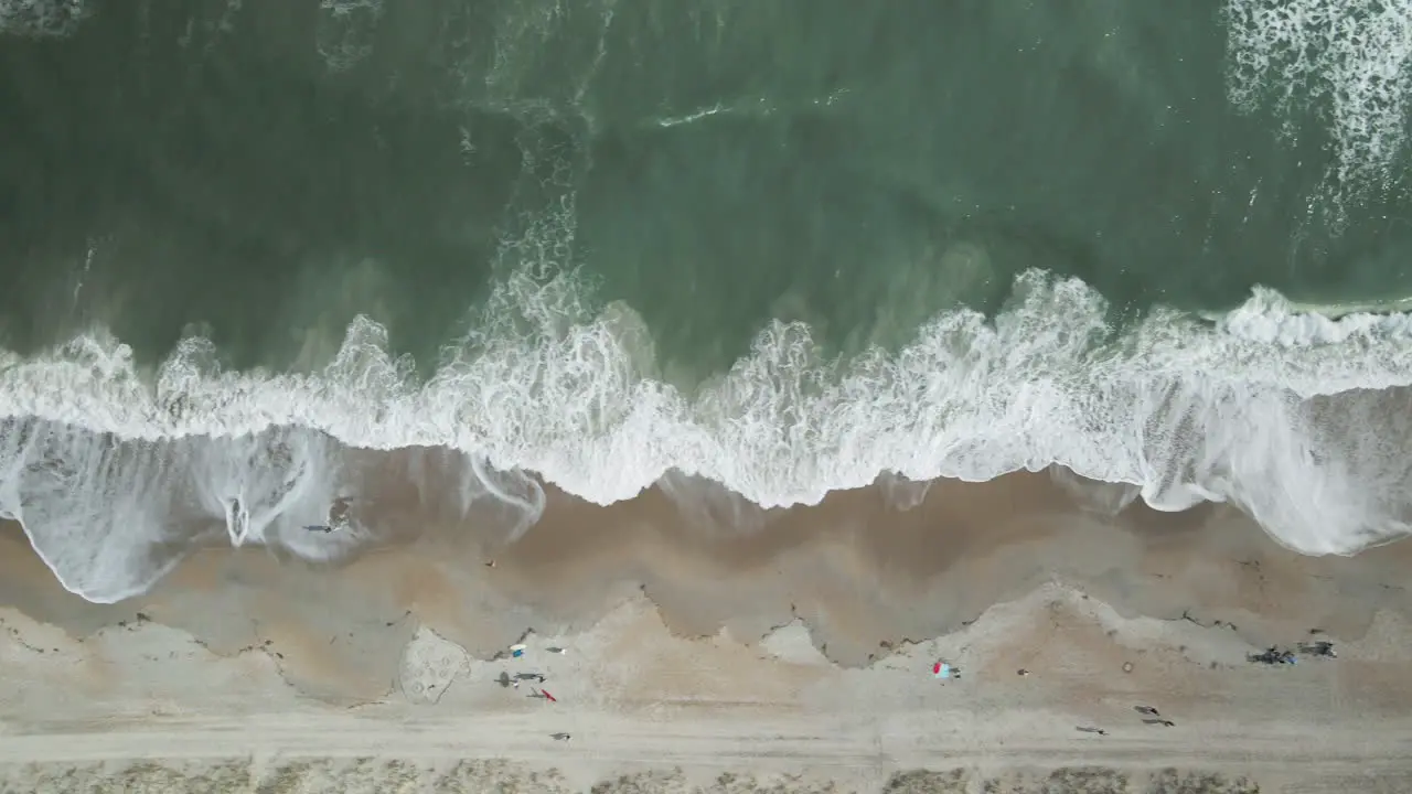 Aerial top-down shot over breaking waves Wrightsville Beach North Carolina TRACKING LEFT TO RIGHT