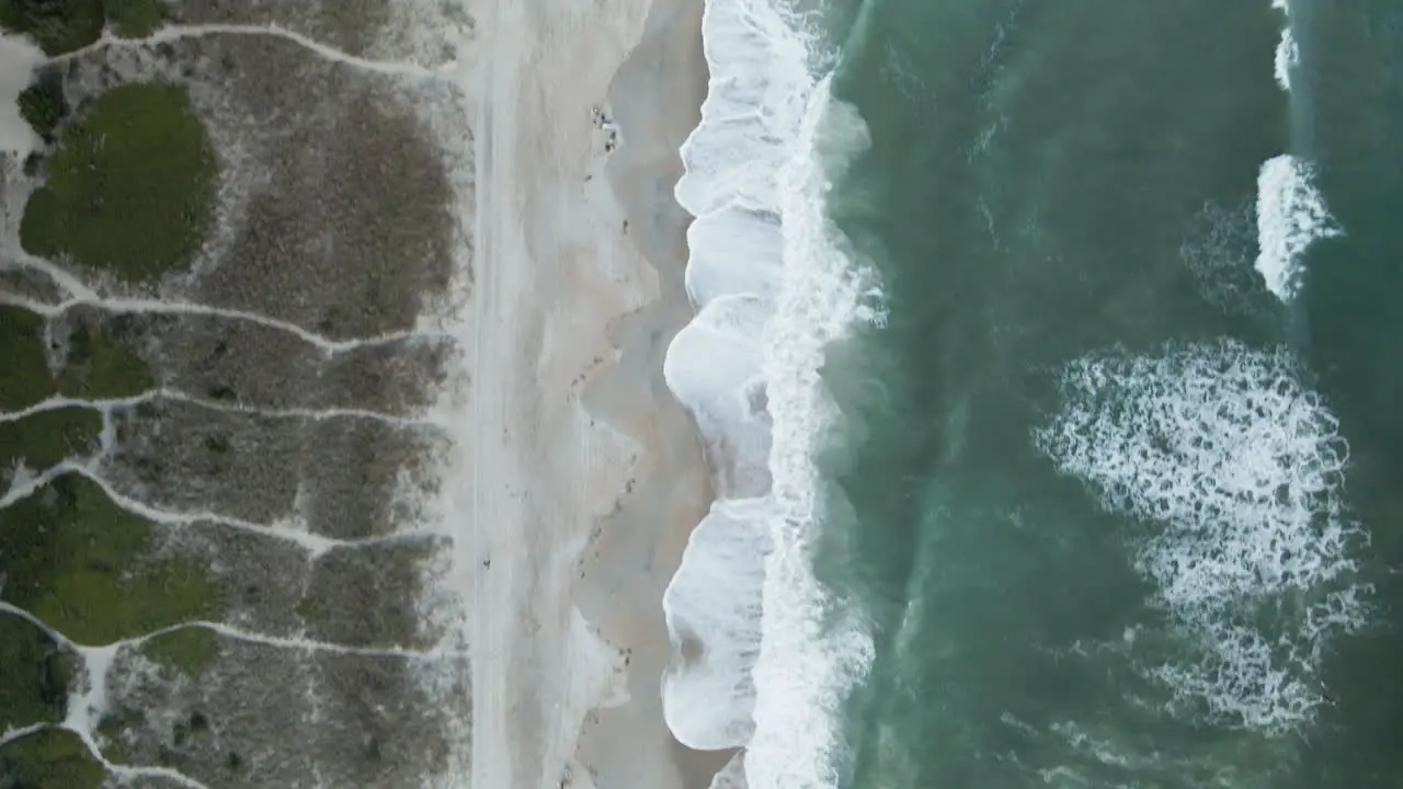 Aerial looking directly down on lapping waves on shoreline of Wrightsville Beach North Carolina