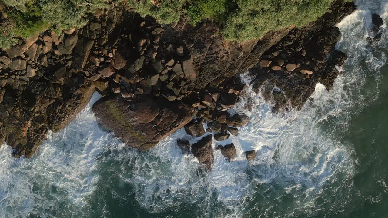 Static Aerial Drone Topdown Shot of Waves Gently Crashing into Rocks on Rocks Coastline in Tropical Country Sri Lanka