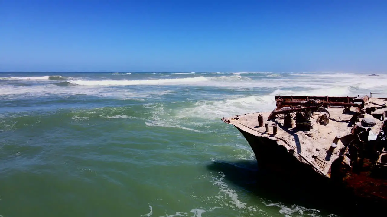 Rusted old shipwreck battered by waves on Cape Agulhas coastline aerial