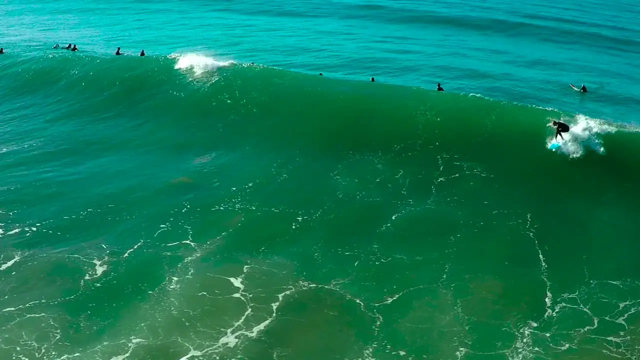 Aerial over surfers riding waves on a Southern California beach