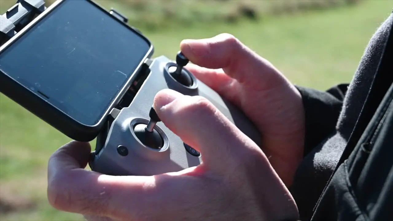 view of a remote control with two joysticks to control a drone telephone attached