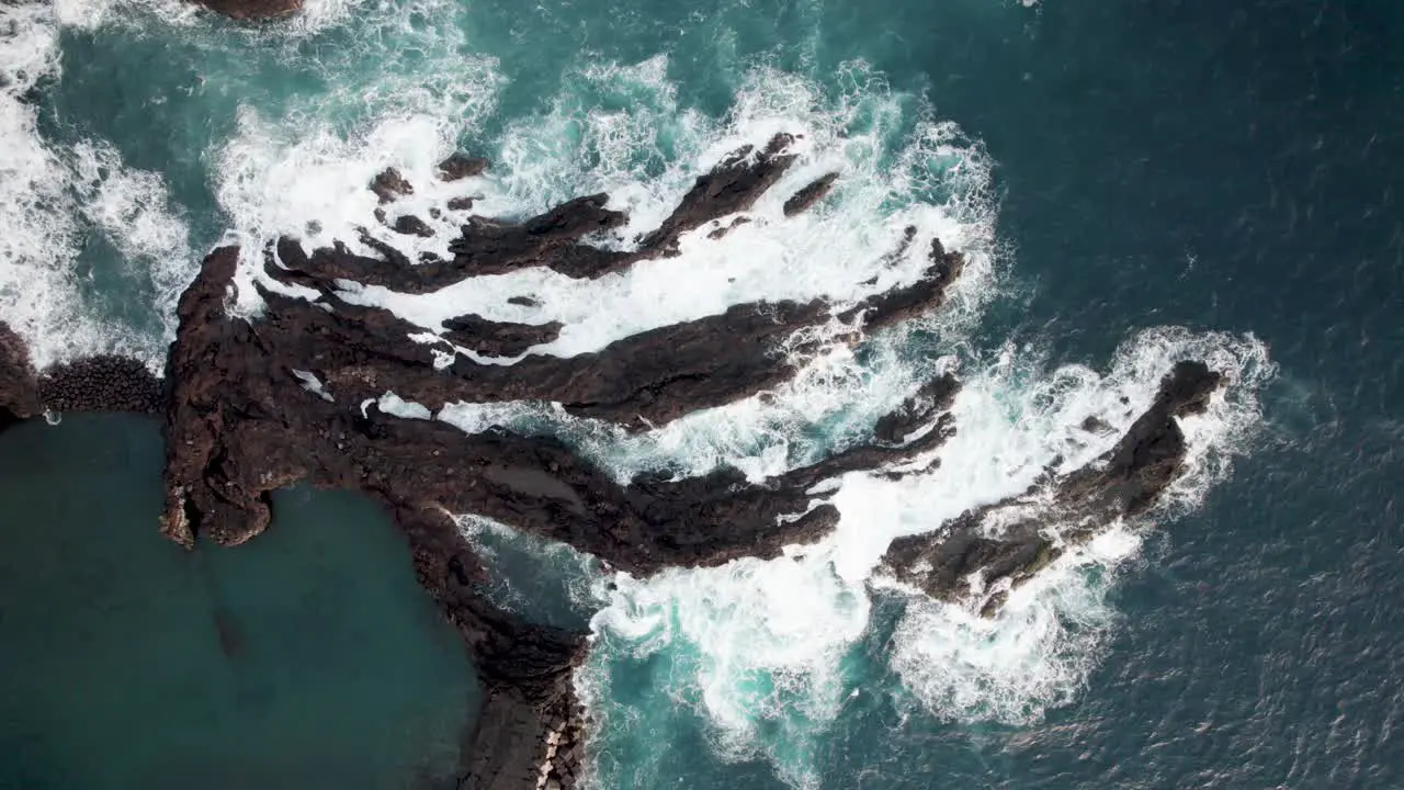 Aerial topdown of waves hitting rocks on coasltine Madiera Portugal