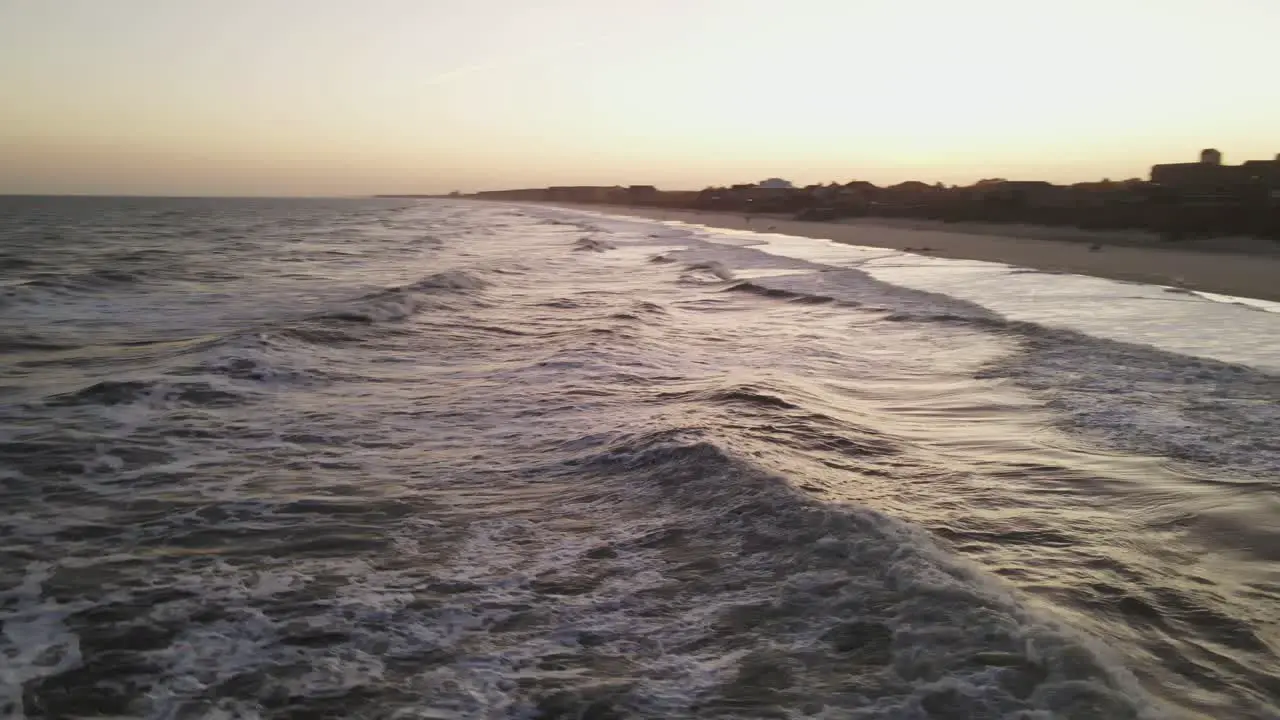 Beach sunset with drone flying with waves