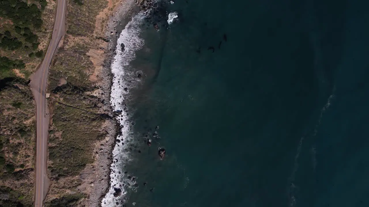 Aerial drone overhead view of a car driving on Highway 1 near Big Sur California