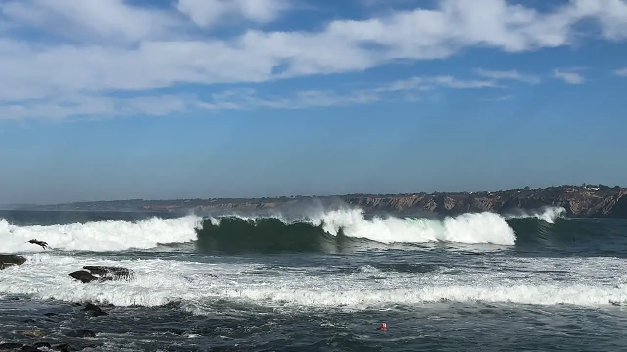 4K Slow motion footage of large ocean waves crashing on cliffs at high tide in La Jolla Cove in San Diego California