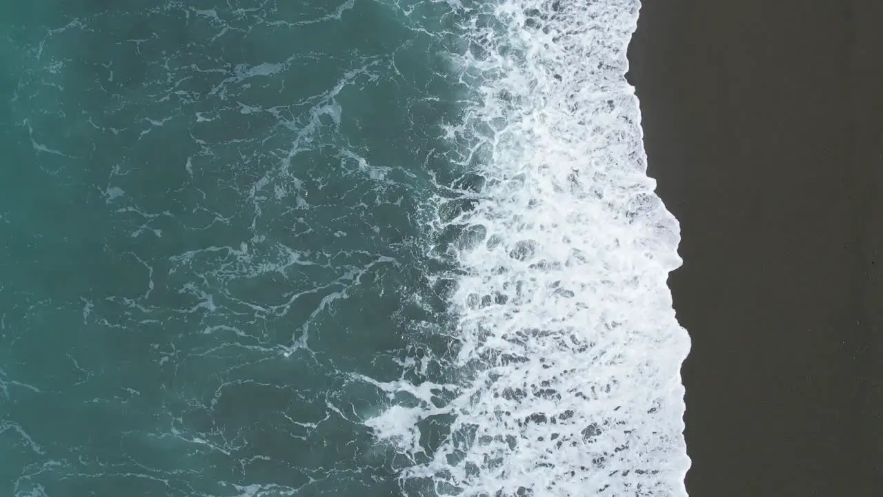 Low aerial slow-motion of sparkling sunlight on breaking waves Birdlings Flat Beach