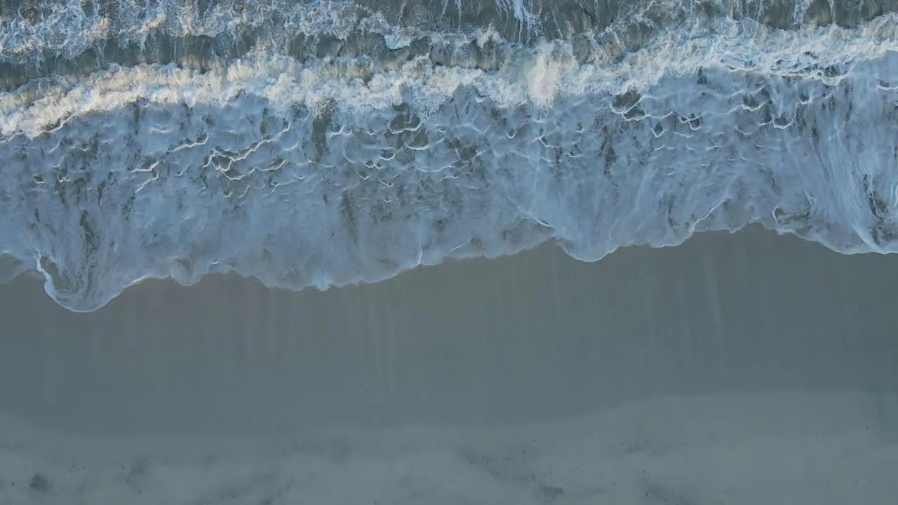 4K Top view of waves breaking on the beach ocean waves crashing and foaming against the empty shore rough sea view