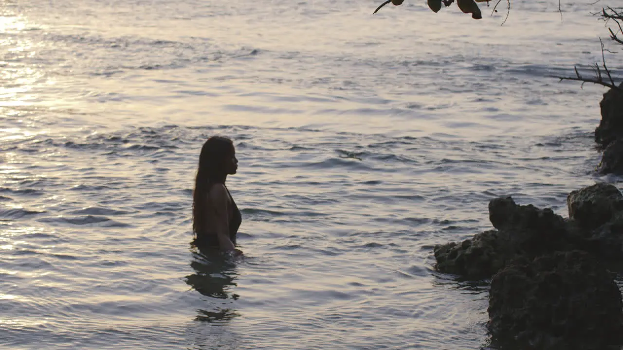 Latin Girl at Sunrise Bathes in Tranquil Early Morning Coastal Sea Waters Static Shot