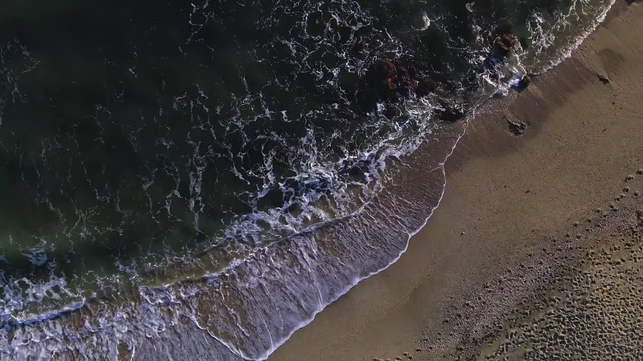 Aerial birdseye view of ocean waves at the beach