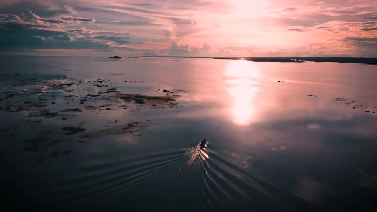 aerial view of a boat in movement in the river with a beautiful sunset