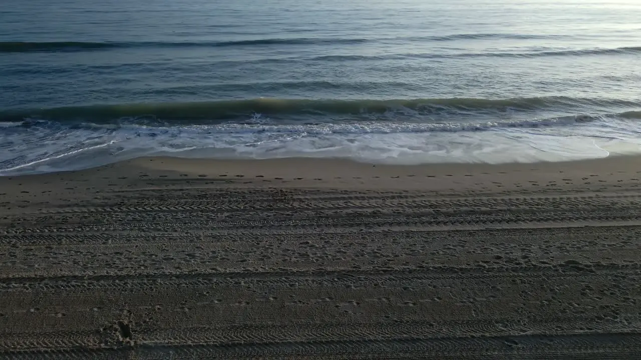 Tilt down static shot of ocean waves at the beach