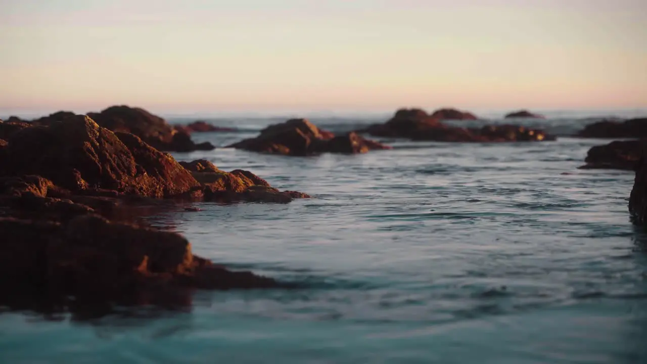 Loop of waves passing slowly by the rocky coastline