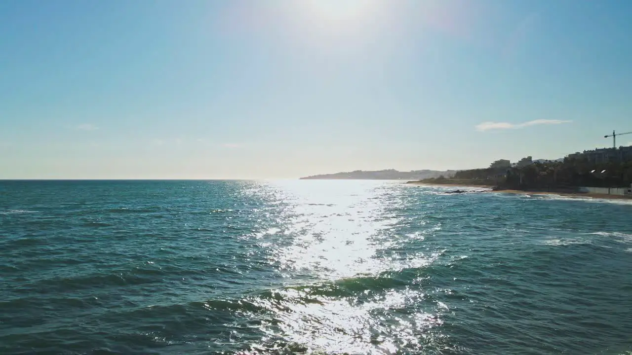 Drone moving backwards in slow motion from the sea into the rocky coast