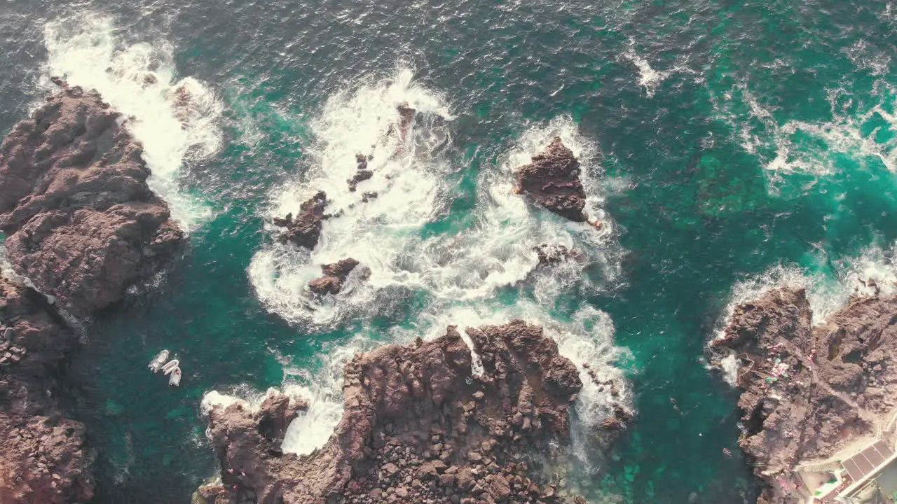 Overhead view of waves splash on rocks