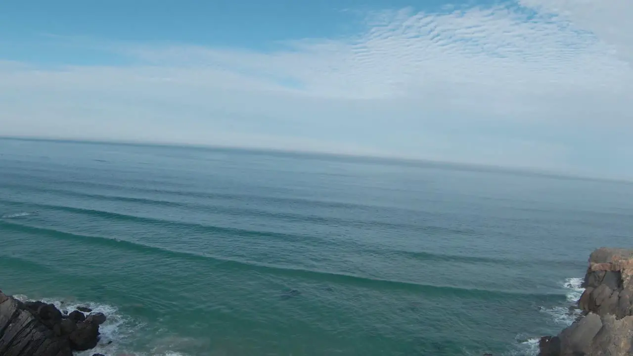 Riding fpv over the sea with some rocks and beauty mountains belongs the natural park