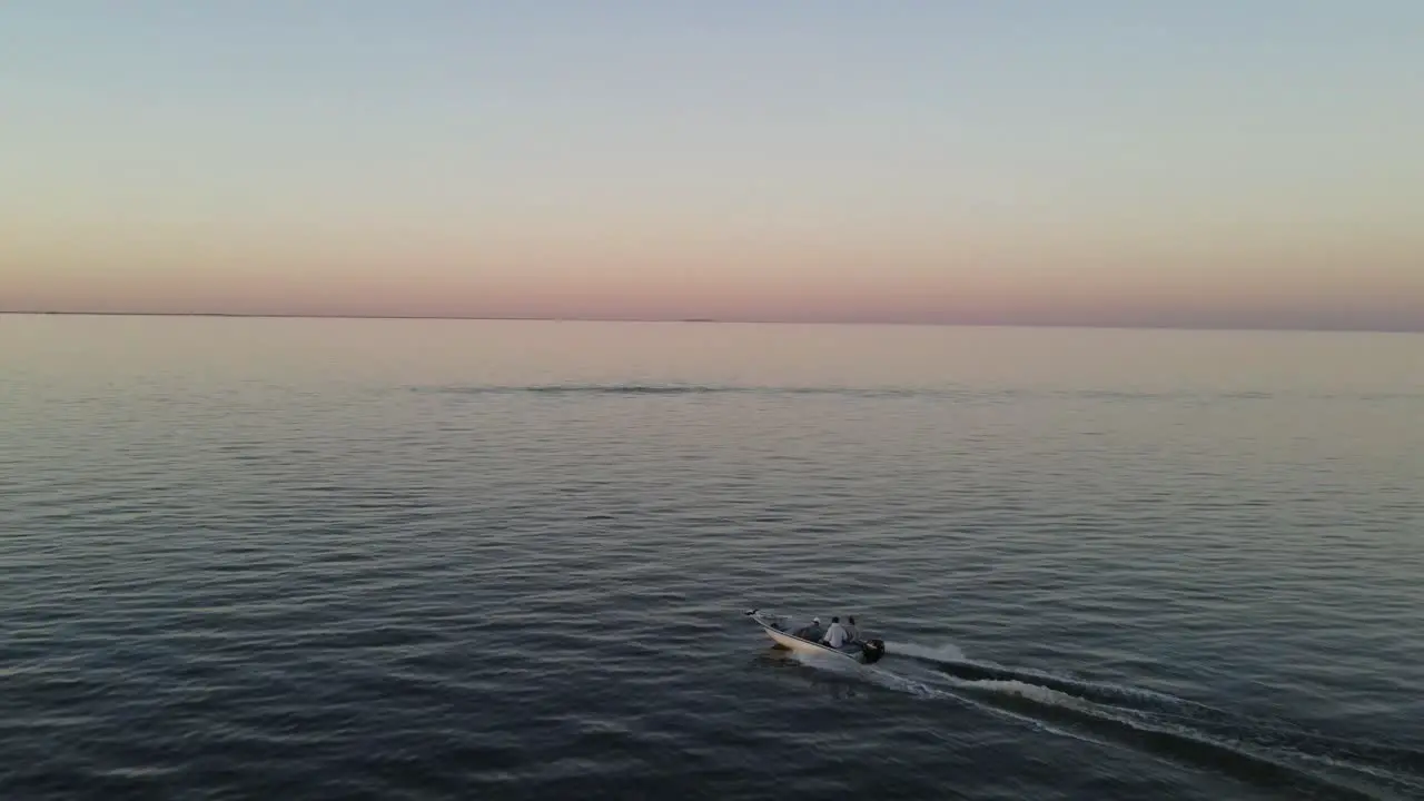 People speeding across the waves in sunset -Aerial